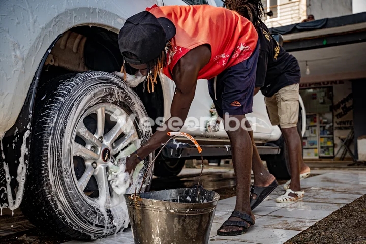 Jeune homme lavant une voiture