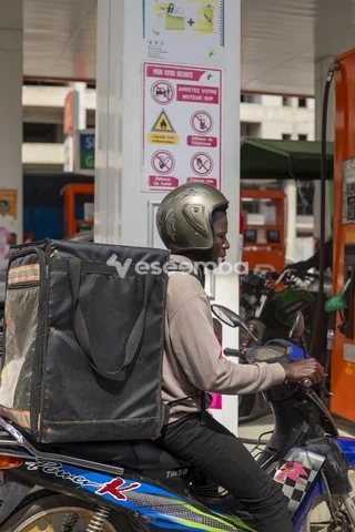 Livreur à moto dans une station-service