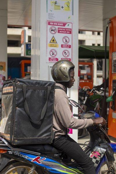 Livreur à moto dans une station-service